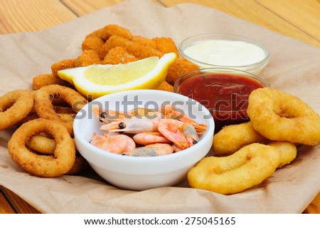 Shrimps, calmar rings and fish sticks with lemon and dip sauces, served as beer snacks