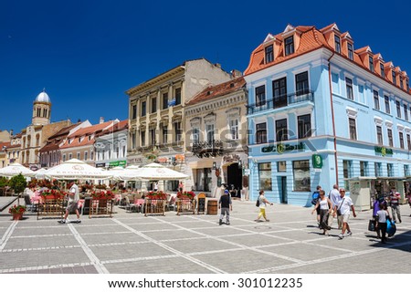 Brasov, Transylvania, Romania, 6th July 2015: Council Square is historical center of city, people walkinng and sitting at outdoor terraces and restaurants.