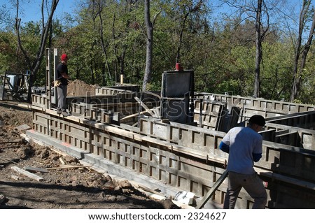 Construction workers and house foundation