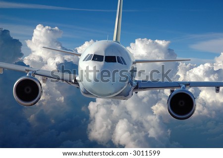 Commercial airliner in flight over a cloud covered background.