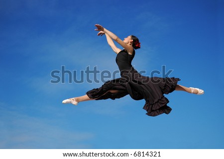 Dancer jumping against blue sky wearing black