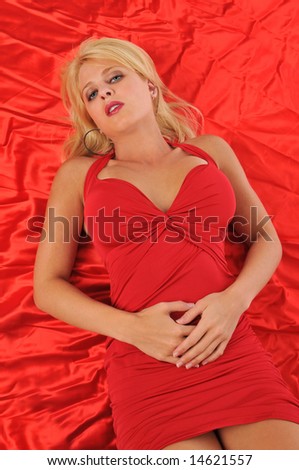 Young blond woman wearing red against a red satin background