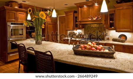 Home Kitchen with Island, Sink, Cabinets, Pendant Lights, Oven, Stove-top Range, and Hardwood Floors in New Luxury House