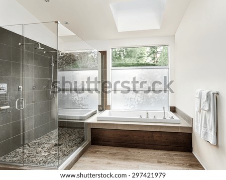 Large furnished bathroom in luxury home with hardwood floor, shower, and bathtub