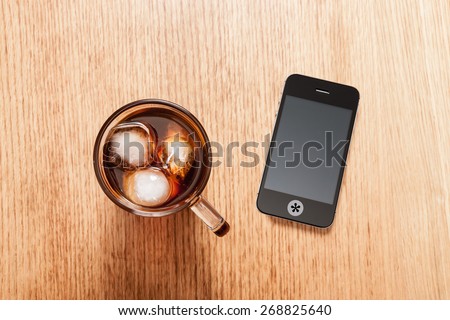 Phone turned off for a relaxing break with a glass of iced coffee.