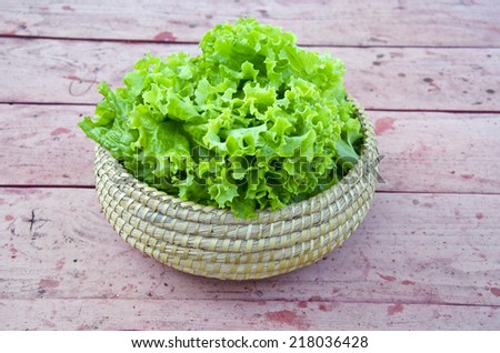 fresh green ecological food  lettuce in wicker plate on table in garden
