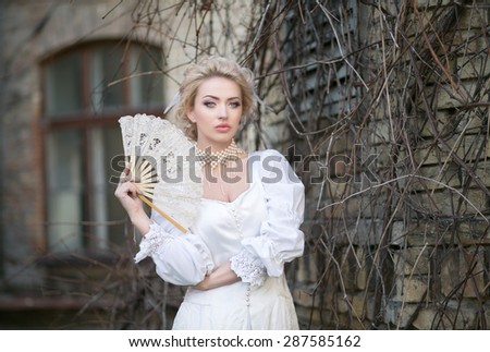 Portrait of a beautiful blonde in an old white dress with a fan in a pearl necklace, beautiful color, toning unusual, mysterious atmosphere, mystic