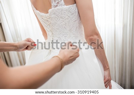 A friend of the bride bride corset laces on a wedding dress