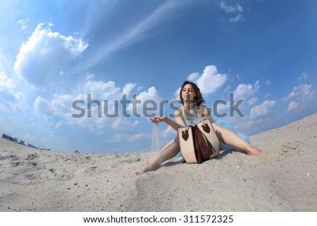 Beautiful young woman in the desert in a long blue dress on a background of blue sky, shot for the magazine, fashion, style, summer,