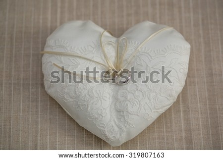 White pillow for wedding rings in a heart