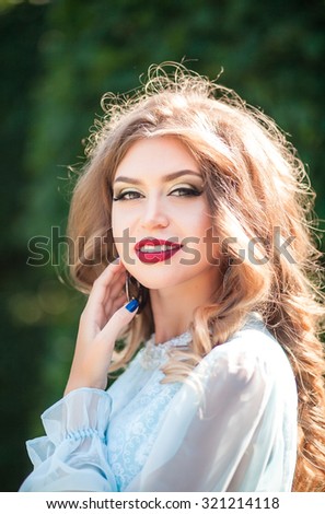 Beautiful girl in a long dress the color of mint walk on summer garden, closeup