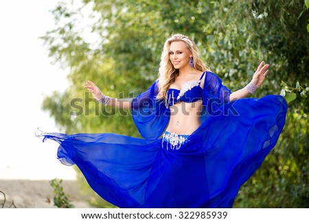 Dancer belly dance in a bright blue dress is ready to fulfill the Arab national oriental dance