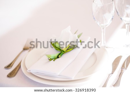 Beautiful serving at banquets, white plate, white tablecloth green ribbon to decorate