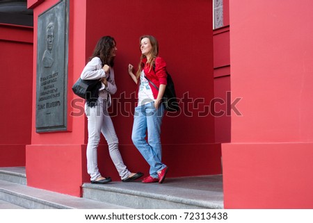 Two students talking near the main entrance of the red building University Shevchenko
