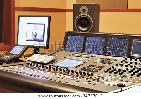 Shot of a recording studio, complete with technition and equipment.