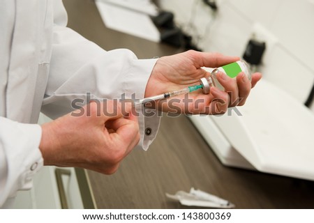 A veterinarian preparing an injection for a cat