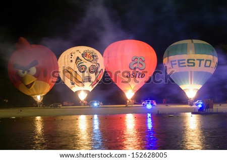 OLDENZAAL, THE NETHERLANDS - AUGUST 23: Four hot air balloons are glowing on the beach of a recreation pond, at a 4 days festival in the Netherlands, Aug 23, 2013.