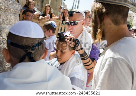 JERUSALEM, ISRAEL - OCT 06, 2014: Bar Mitzvah ritual at the Wailing wall in Jerusalem. A 13 years old boy who has become Bar Mitzvah is morally and ethically responsible for his decisions and actions
