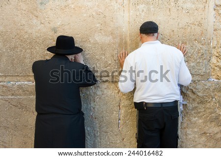 JERUSALEM, ISRAEL - OCT 06, 2014: Two jewish man are praying against the western wall in the old city of Jerusalem