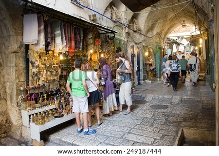JERUSALEM, ISRAEL - OCTOBER 07, 2014: People are watching at souvenirs in one of the shops of the small streets in the old city of Jerusalem