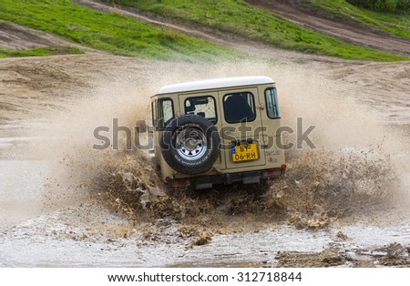 FURSTENAU, GERMANY - MAY 09, 2015: A Toyota 4-wheel drive is driving through a pond of water on a special off the road terrain for land cruisers and vehicles in Germany