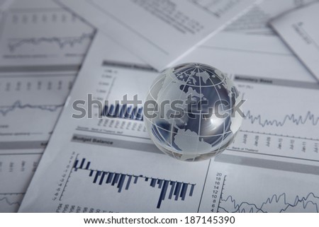 Glass globe on the chart papers.