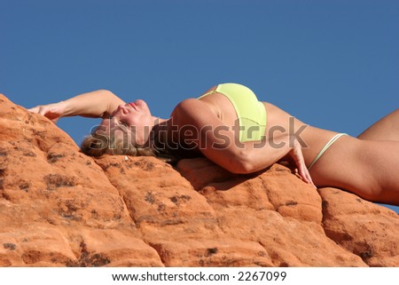 Sexy woman lying on red rocks