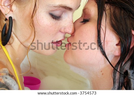Two women kissing in bathtub
