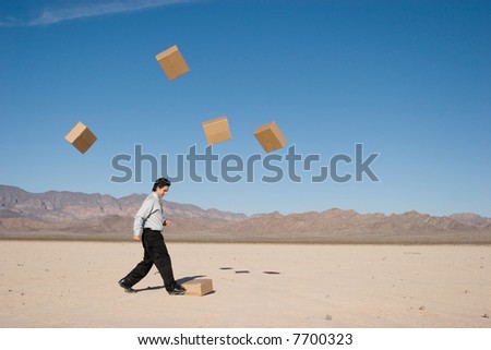 Businessman kicking boxes in the air