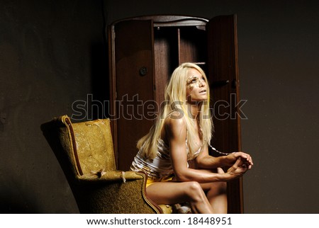 Sexy blond woman in mini skirt sitting on a chair