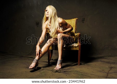 Sexy blond woman in mini skirt sitting on a chair