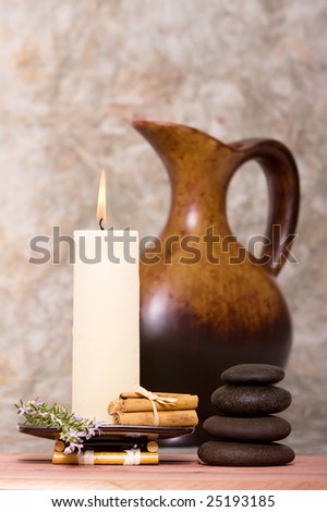 Spa candle, massage stones with cinnamon sticks