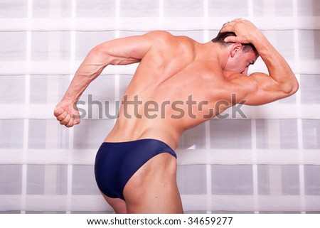 Muscular body builder showing his muscles
