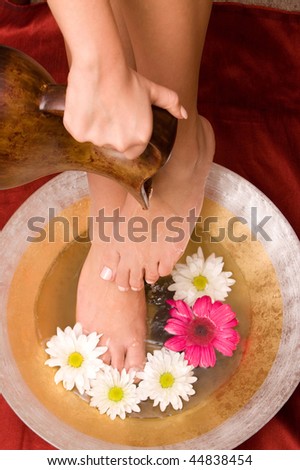 Woman washing her feet in a bowl of water