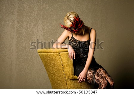 Beautiful girl wearing mask and sitting on an old chair