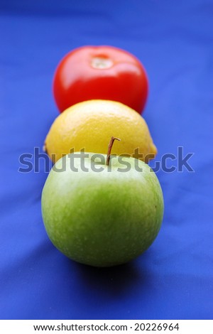Concept of fruits representing traffic light on blue background (perspective with thin depth of field)