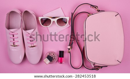 beautiful women\'s minimal set of fashion accessories on a pink background: shoes, sunglasses, perfume, nail polish and handbag. Ideal for blogs or magazines. Mock up.