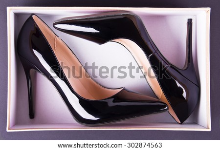 Beautiful classic women shoes on high heels in a box on a black background. Ideal for blogs or magazines.