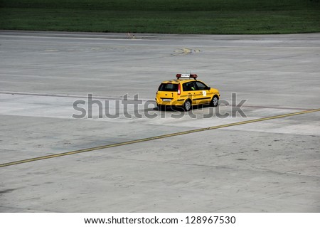 KATOWICE, POLAND - SEPTEMBER 3: Yellow Follow Me car parked on September 3, 2011 on the airport field in Katowice, Poland. Follow Me car help is required for night flights.