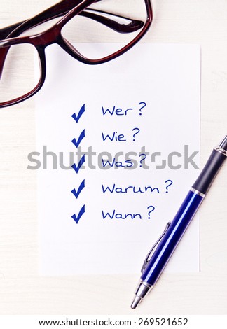 chicklist on desktop with office supplies - german for who how what why when
