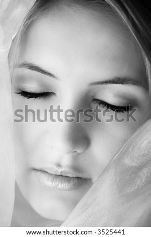 beauty portrait of a young and beautiful woman with a shawl on her face