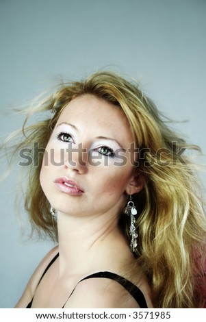 beauty portrait of a woman with earrings and wind on her hair