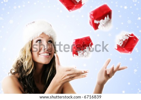 winter portrait of a beautiful young smiling woman with falling gifts