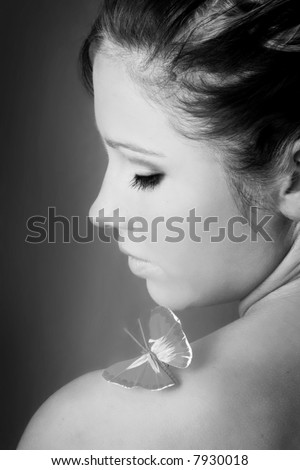 beauty portrait of a beautiful young woman with a butterfly on her shoulder