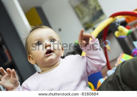 baby playing in a bedroom - hands in the air