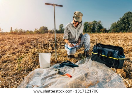Soil Test. Female agronomist taking notes in the field. Environmental protection, organic soil certification, research Foto d'archivio © 