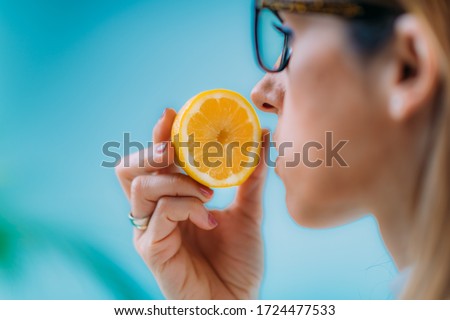 Anosmia or smell blindness, loss of the ability to smell, one of the possible symptoms of covid-19, infectious disease caused by corona virus. Woman Trying to Sense Smell of a Lemon Foto d'archivio © 
