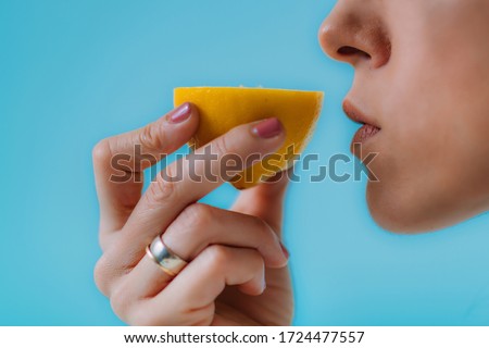 Anosmia or smell blindness, loss of the ability to smell, one of the possible symptoms of covid-19, infectious disease caused by corona virus. Woman Trying to Sense Smell of a Lemon Foto d'archivio © 