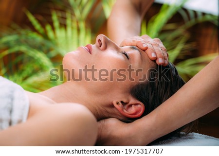 Craniosacral therapy massage. Therapist massaging woman’s forehead.