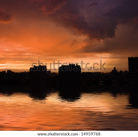 Storm clouds above water with silhouettes of houses on horizon